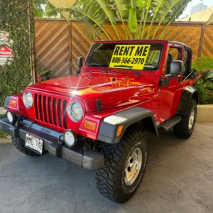 Bright red vintage Jeep parked for rental in Waikiki