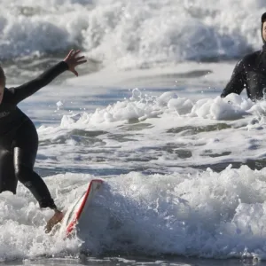 Two kids sharing semi-private surf lesson on island beach