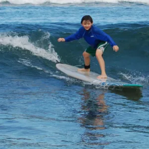 Young child learning to surf with private instructor