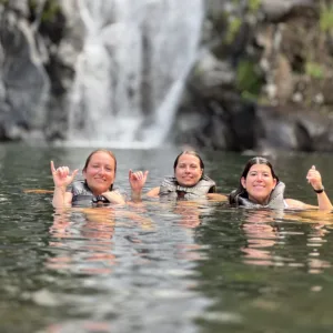 Hikers exploring lush island trails with waterfall views