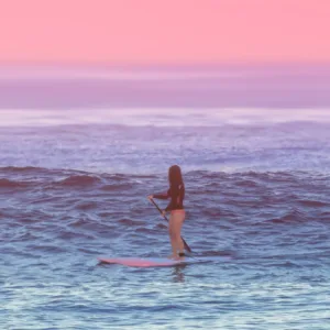 Stand up paddleboarders learning on calm water