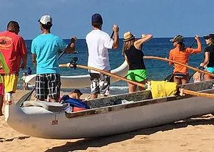 Hawaiian outrigger canoe gliding through ocean waves