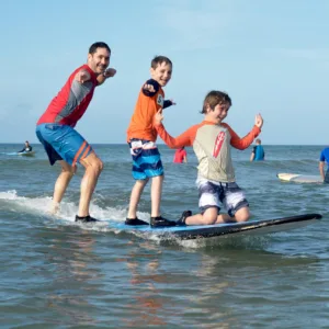 Surf instructor guiding student on gentle waves