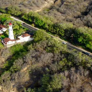 Circle island tour boat cruising along volcanic coastline