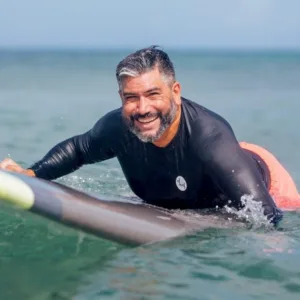 Individual receiving private surf coaching on beach