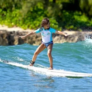Group of beginners learning to surf at sunset