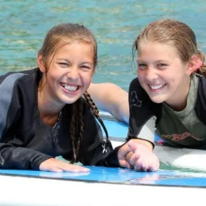 Small group receiving guided surf lesson at sunset
