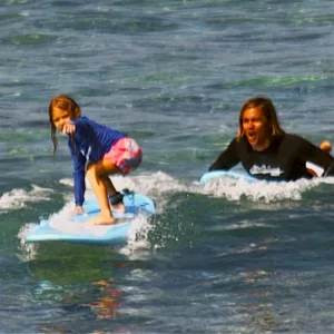 Instructor guiding student on private surf lesson