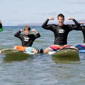 Beginner surfer catching waves at Maui surf camp