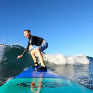 Surf instructor guiding a student on Maui’s beach