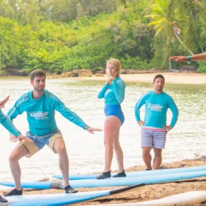 Group enjoying a surf lesson on sunny beach