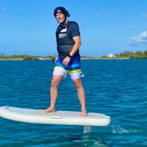 Participant learning to ride an eFoil on calm water