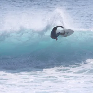 Experienced surfers catching waves during advanced group lesson