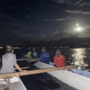 Group enjoying a full moon paddle on calm waters