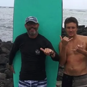 Instructor giving a private surf lesson on Kona’s sandy beach