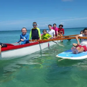 Junior waterman exploring island waves with surfboard