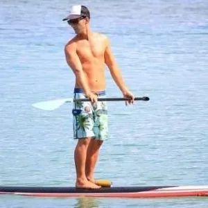 People enjoying paddleboarding on calm island waters
