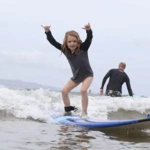 Instructor guiding a student during surf lesson in Maui
