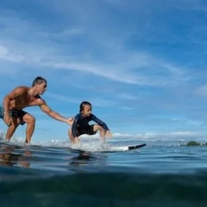 Instructor giving private surf lessons to student on Waikiki beach