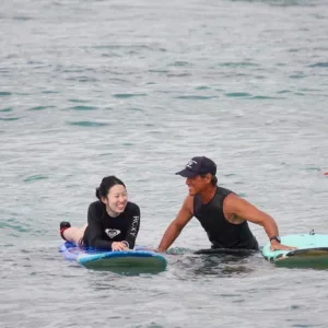 Instructor guiding beginner on Waikiki surfboard