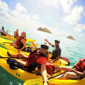 Two people paddling a kayak on clear blue water
