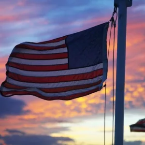 Boat sailing at sunset with colorful fireworks in background