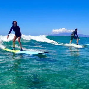Instructor giving semi-private surf lesson to two students