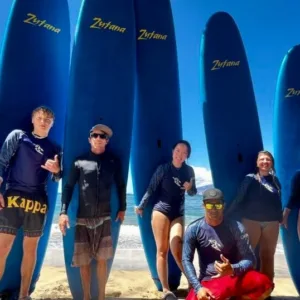 Group of surfers catching waves during a mixed group lesson