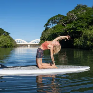 Group practicing yoga on paddleboards in calm water