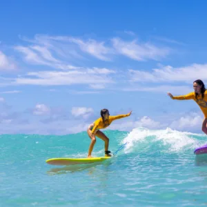 Group of four to five people surfing together on waves