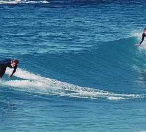 Group learning to skimboard together on a sandy beach