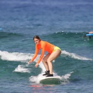 Group of four learning to surf together in lesson