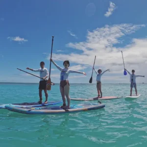 Participants learning stand-up paddleboarding in group lesson