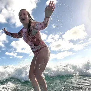 Instructor giving a private surf lesson on calm ocean waves
