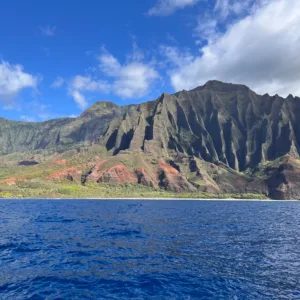 Boat cruising along the Na Pali Coast cliffs