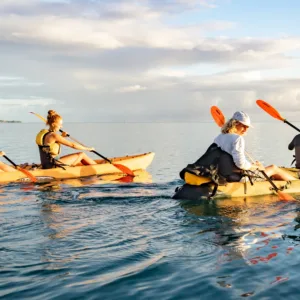 Kayakers paddling through calm Kailua waters at sunrise