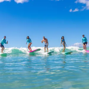 Family enjoying surfing lesson together on sandy beach