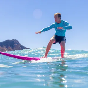 Individual receiving personalized surf coaching on calm beach