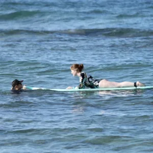 Private surf instructor guiding lesson on tropical island beach