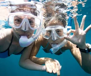 Beginner snorkelers practicing skills in calm swimming pool