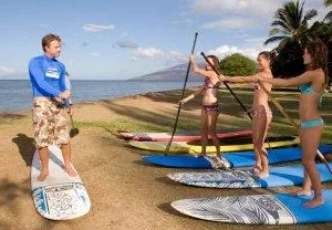 Person balancing on stand-up paddleboard near Waikiki beach