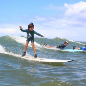 Children learning to surf in a fun island camp setting