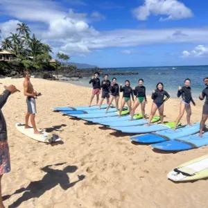 Instructors teaching surf techniques to private group in Hawaii