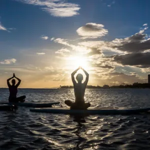 Practice yoga on a stand-up paddleboard in calm waters