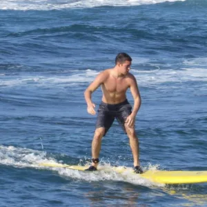 Beginner surfer catching small wave at Poipu beach