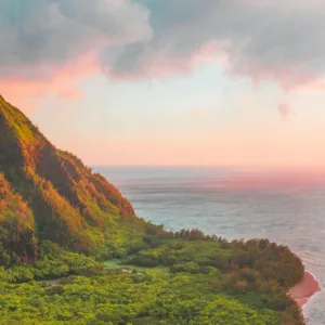 Boat cruising along Nāpali coast during golden hour