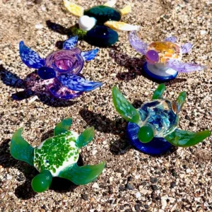 Artist shaping molten glass in flameworking studio workshop