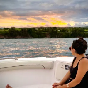 Boat cruising Hilo Bay at sunset with colorful sky