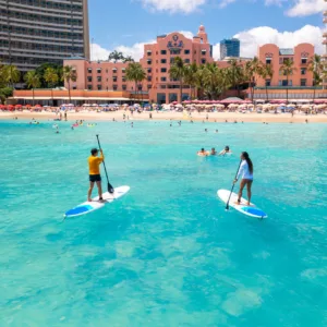 Individual receiving one-on-one stand-up paddleboarding lesson