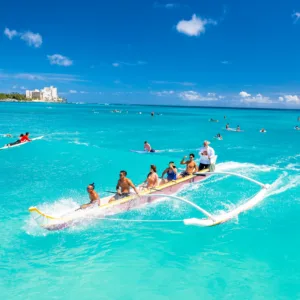 Group riding traditional canoe waves during surfing session